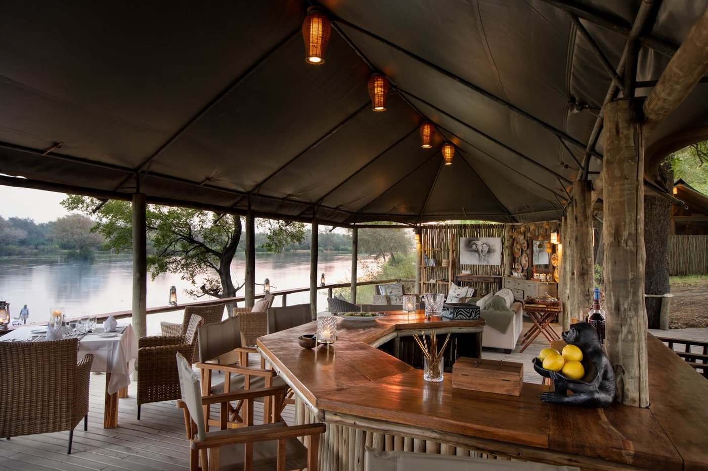 Offene Bar und Lounge mit Blick auf den Zambezi River in der Dämmerung von Amanzi.