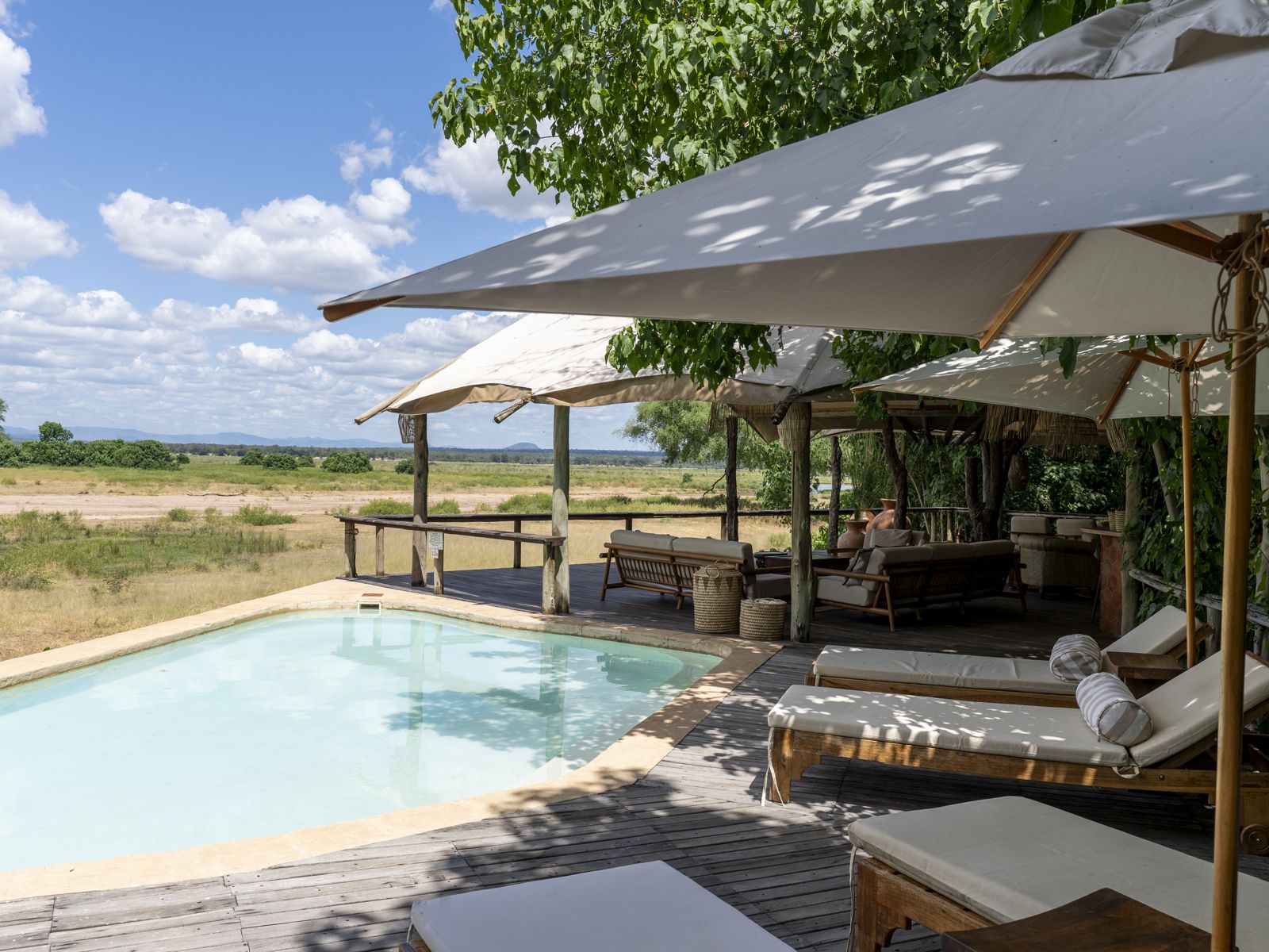 La piscine sur la terrasse de Mushika, avec des parasols face à la plaine d'inondation