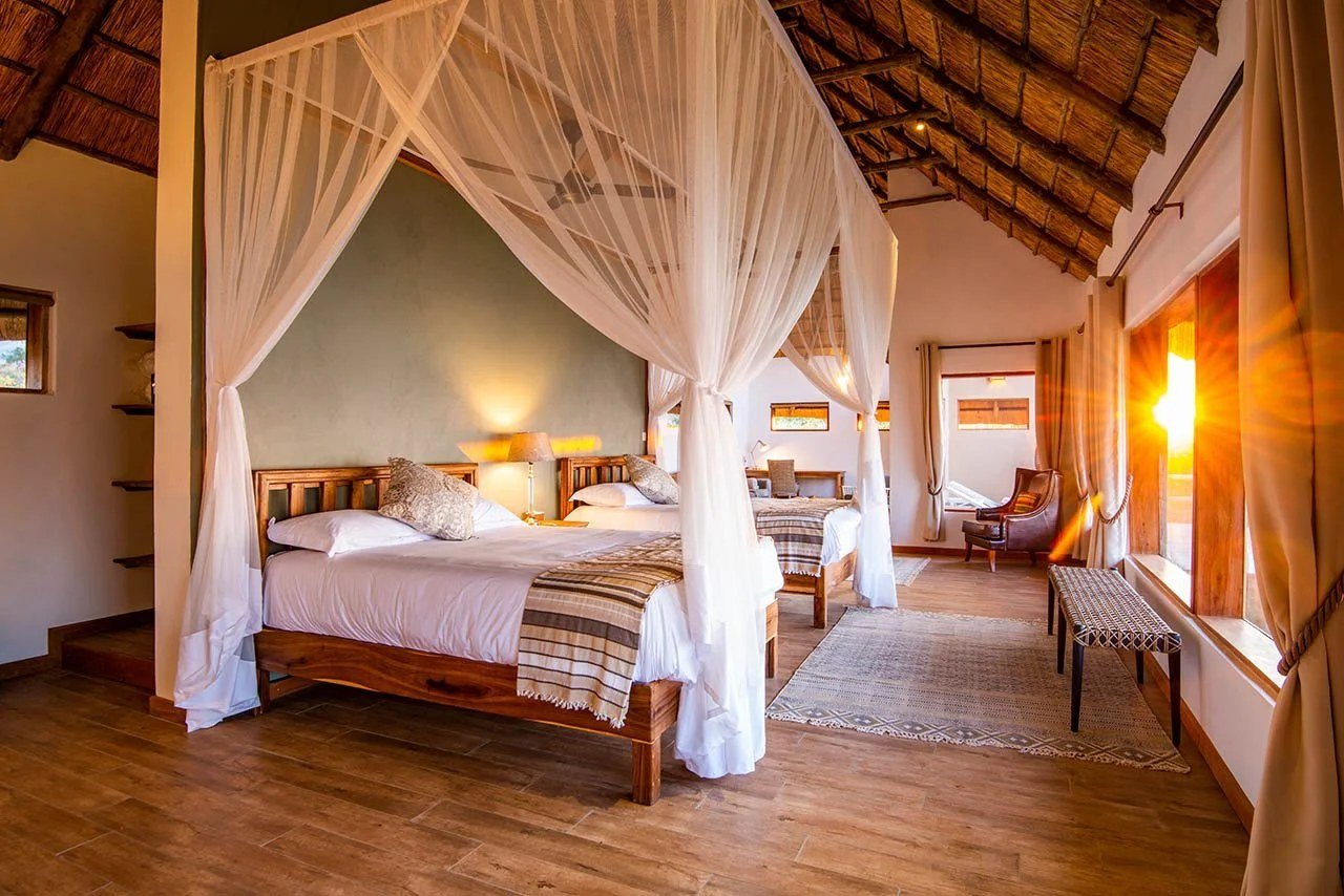 Ein Himmelbett glänzt unter Moskitonetz in einer Suite der Kayila Lodge