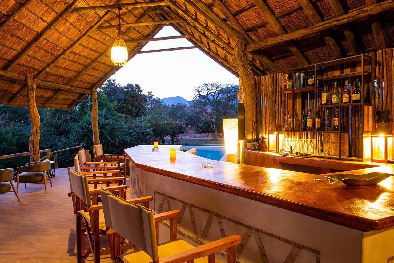 Die offene Bar blickt bei Sonnenuntergang auf den Fluss an Kayila Lodge