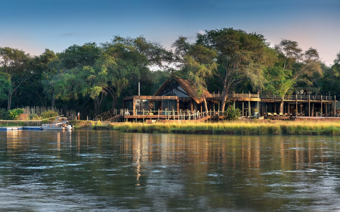 Le lodge aux murs vitrés et au toit de chaume de Lolebezi s'élève au-dessus de la berge en Lower Zambezi.