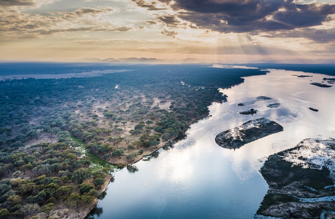 Une vue aérienne du fleuve Zambezi s'incurvant devant la plaine d'inondation et la forêt près d'Old Mondoro.