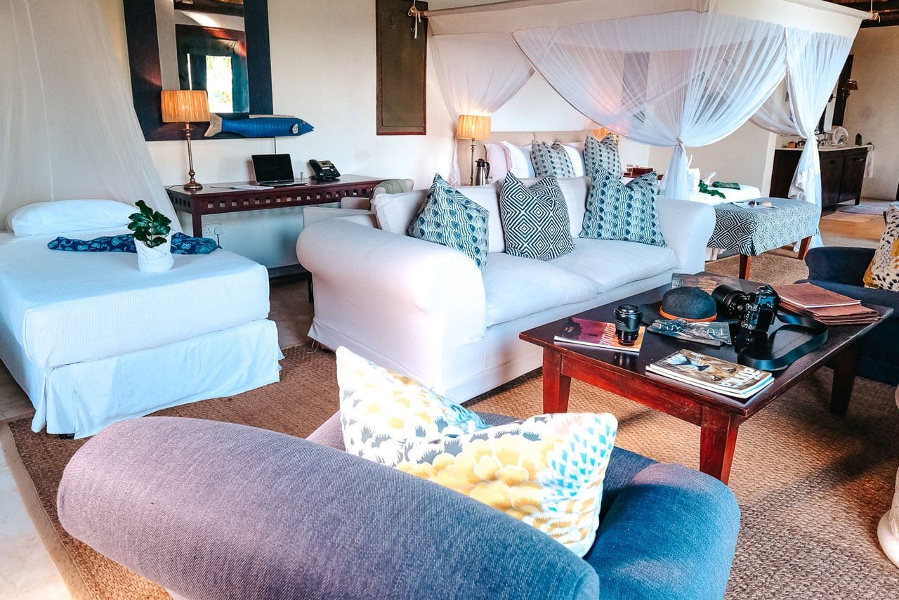 Des canapés blancs et des coussins motifs meublent le salon au toit de chaume de Royal Zambezi Lodge.
