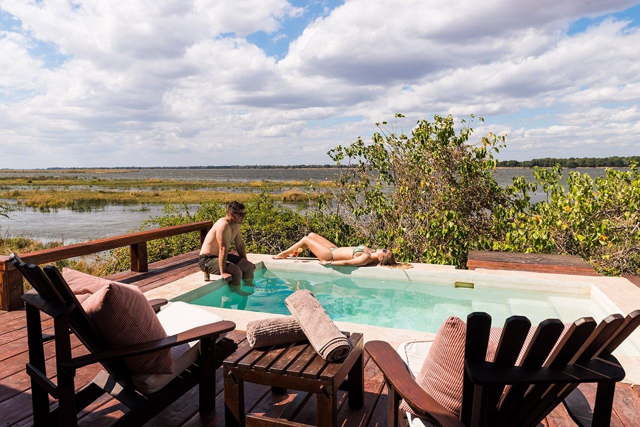 Un client se détend près de la piscine surplombant la plaine inondable à Royal Zambezi Lodge.