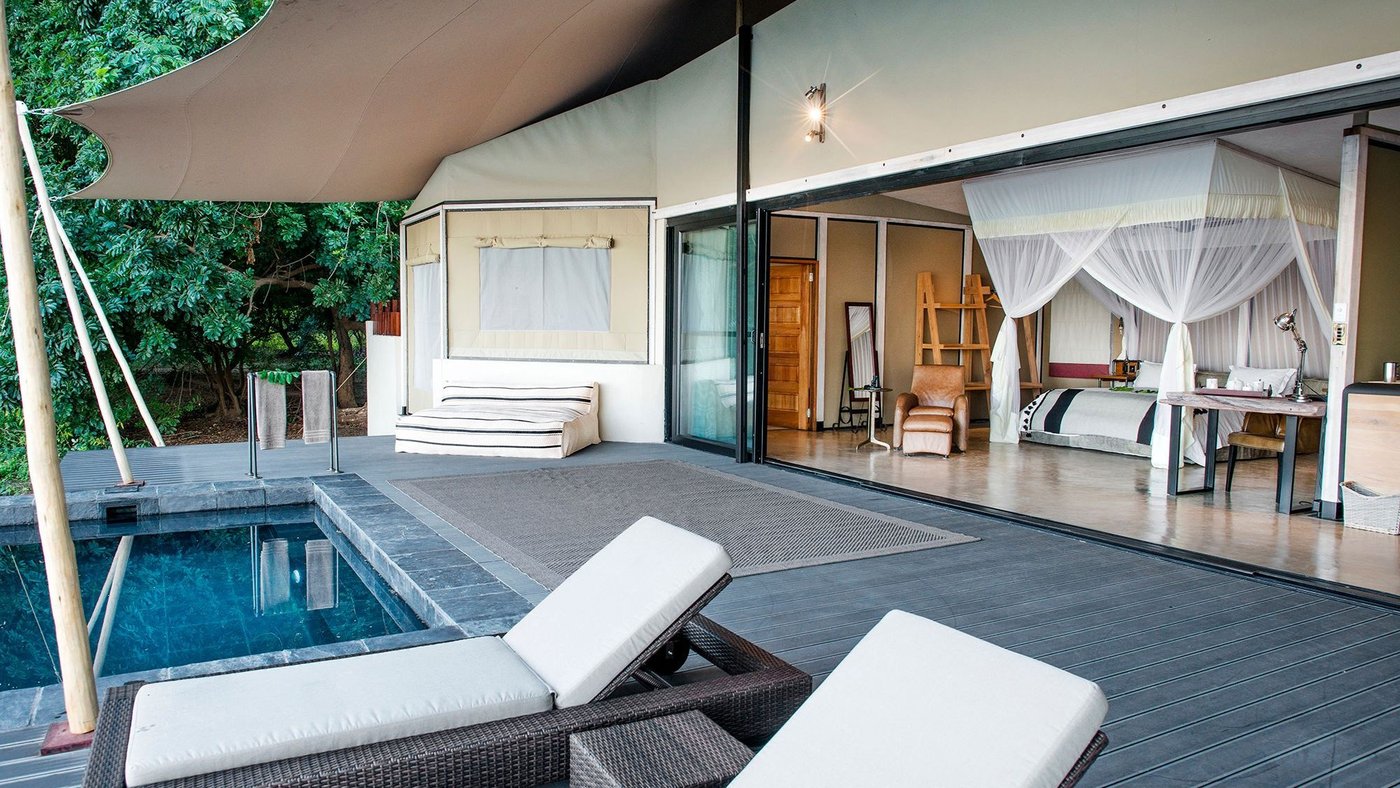 Ein privates Tauchbecken und Liegen vor einer offenseitigen Suite im Sausage Tree Camp.