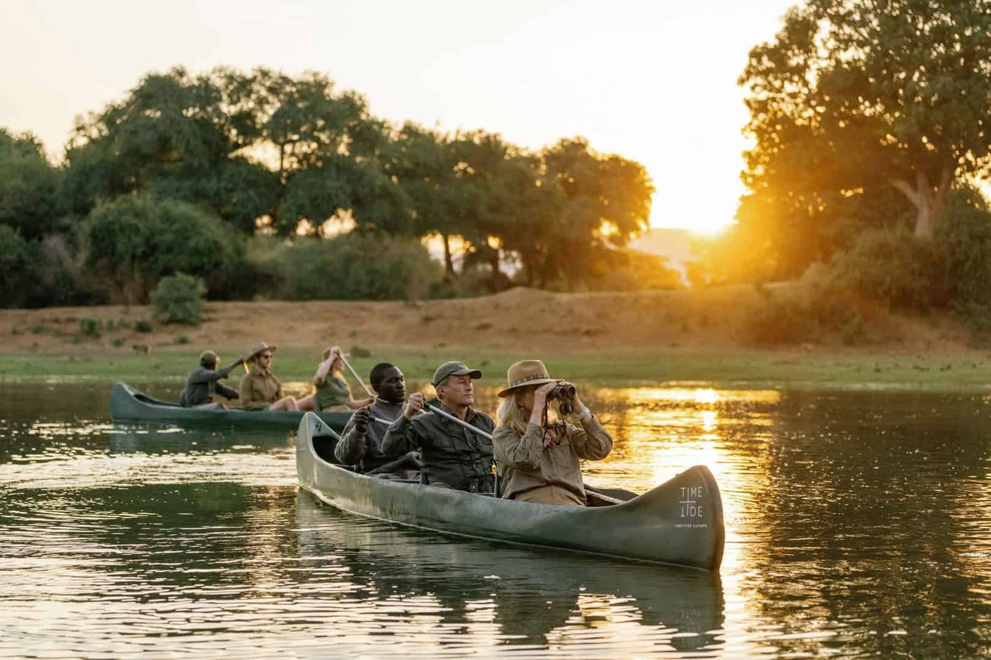 Les guides pagaient les canoés avec les invités sur des eaux calmes à l'aube depuis le camp Time and Tide Chongwe.