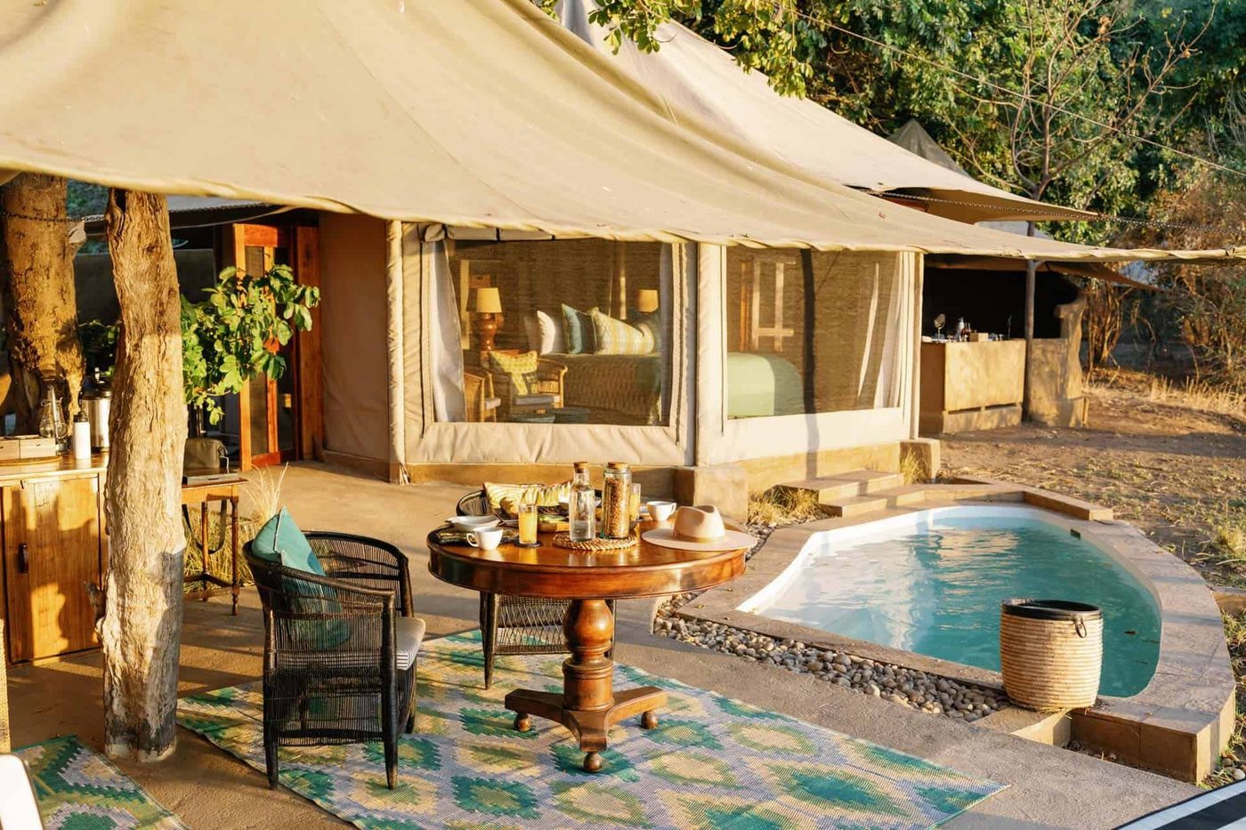 Un petit bassin et une table de petit-déjeuner se trouvent devant les suites Time and Tide Chongwe à Lower Zambezi.