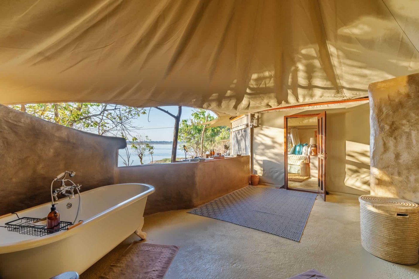 Eine freistehende Badewanne blickt auf den Zambezi River bei Time and Tide Chongwe Suites.