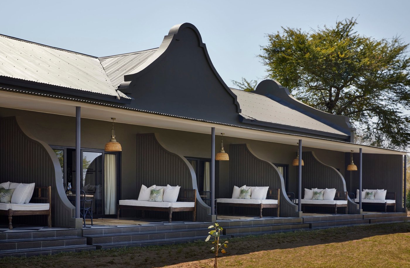 Eine Reihe von Bungalows mit muschelnförmigen Strohdächern fängt das Abendlicht am Zambezi Grande.