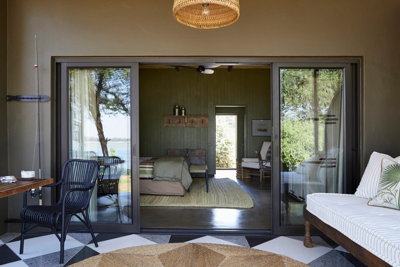Ein Schlafzimmer mit schwarzen und weißen Fliesenböden öffnet sich zum Garten am Zambezi Grande.