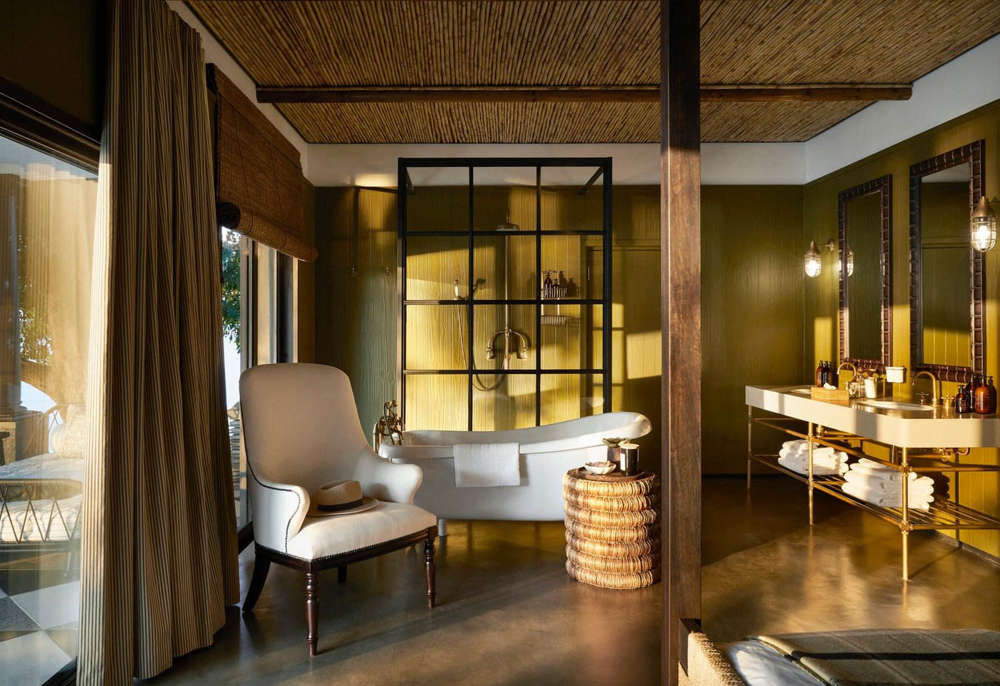 Eine freistehende Badewanne und eine Glasdusche gestalten das olivfarbene Badezimmer am Zambezi Grande.